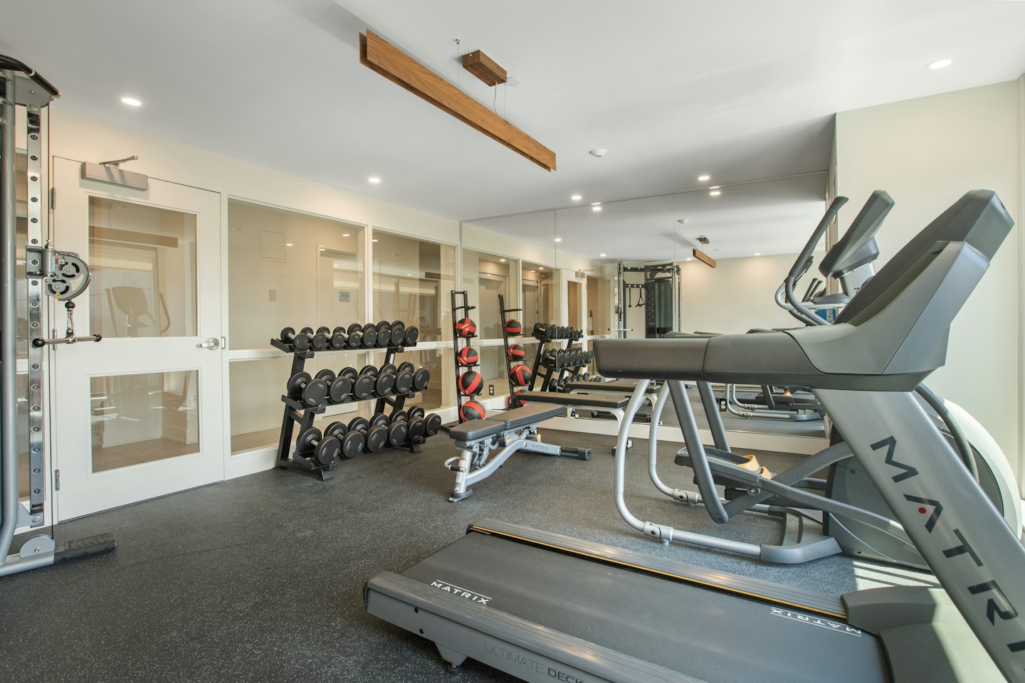 Modern gym with treadmills, weights, and exercise equipment.