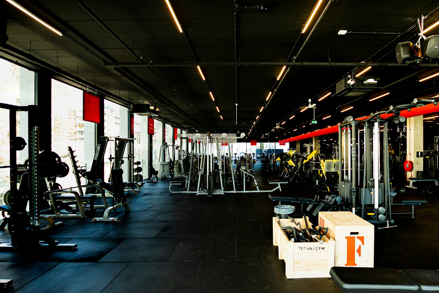 Modern gym with weights and exercise machines on rubber floor.